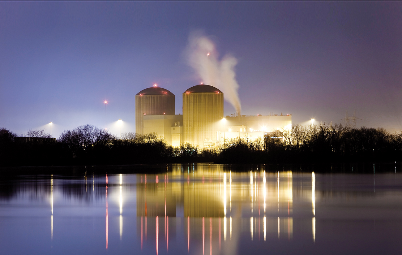 Nuclear Power Plant at Night with Water Reflections