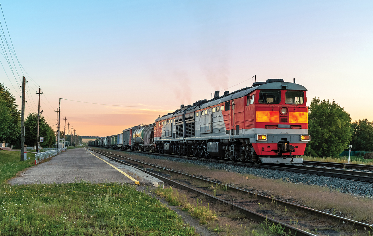Powerful diesel locomotive with a heavy freight train in a beautiful sunset light